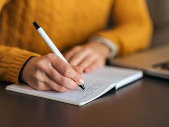 person sitting at desk taking notes